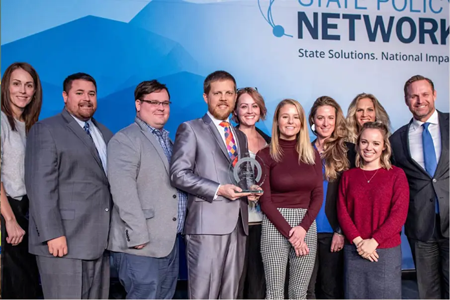 Group photo at a State Policy Network event with people holding an award.